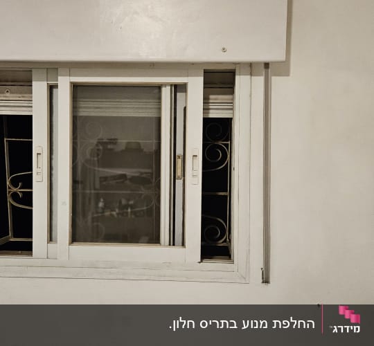 חלון עם תריסים לבנים סגורים חלקית